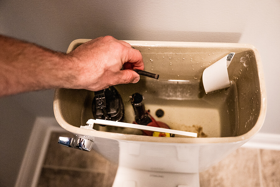 Atlas Butler plumber fixing a toilet in a Columbus Ohio, home ensuring smooth and efficient plumbing operations.