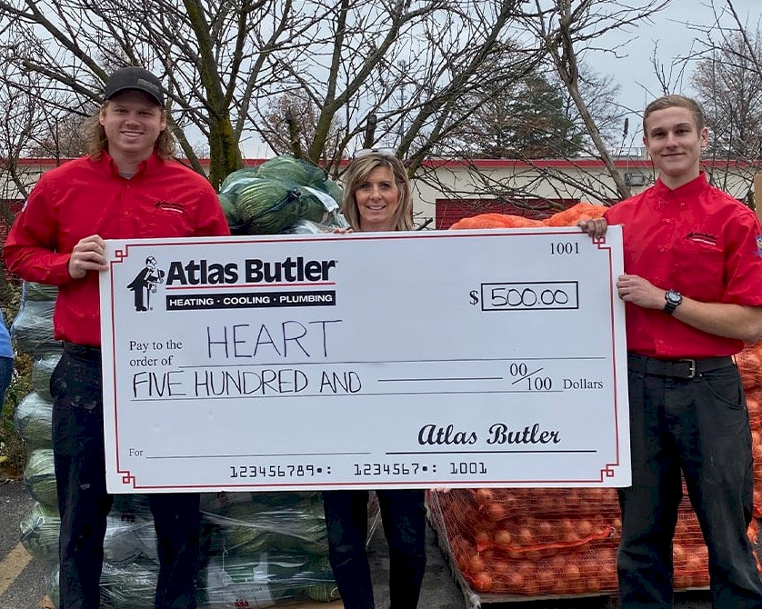 Atlas Butler HVAC Technicians holding a donation check for the Mid-Ohio HEART (Helping Eastside and Reynoldsburg Thrive) Market Model Food Pantry.