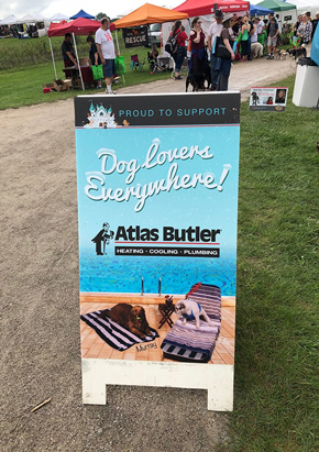 Atlas Butler is 'Proud to support dog lovers everywhere' sign at Columbus Wagfest charity event.